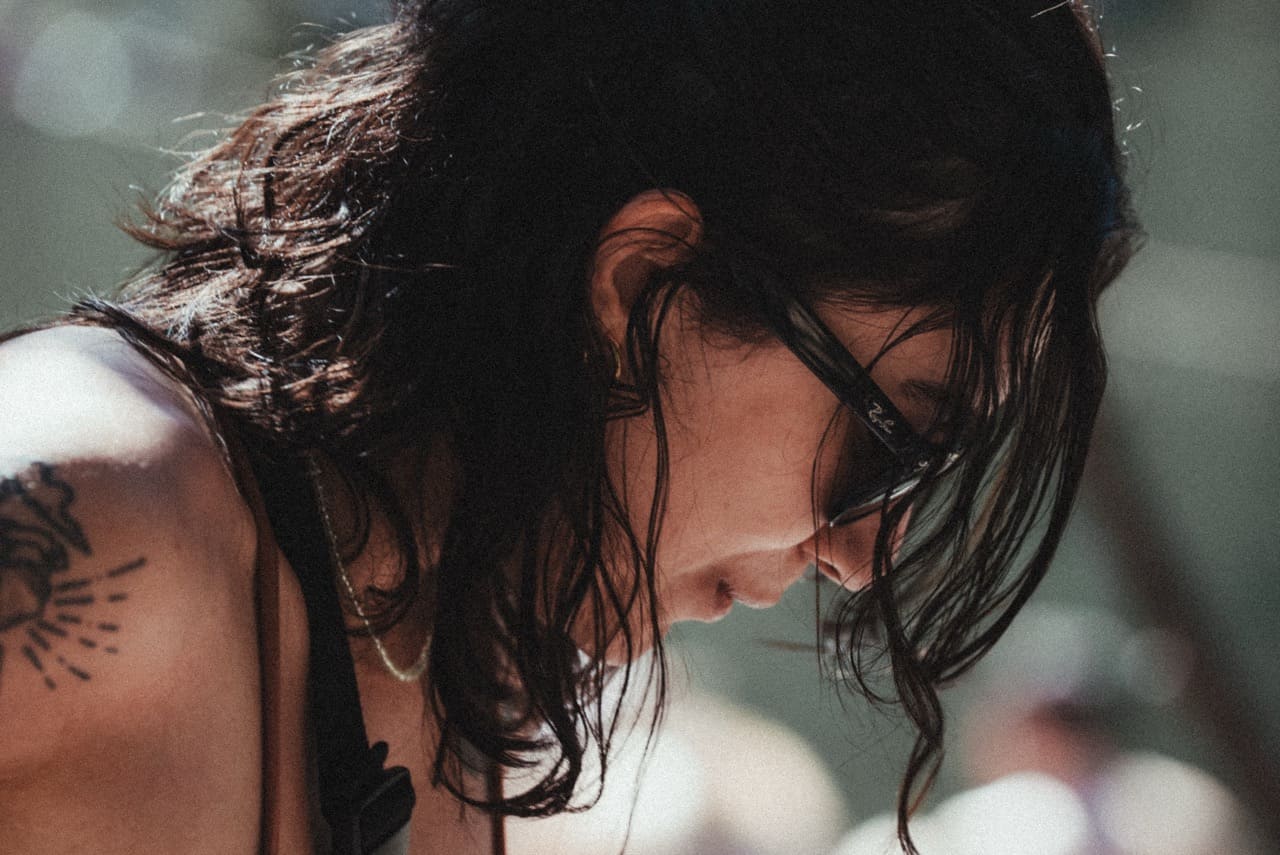 Perfil, cabelo molhado e tatuagem de sol