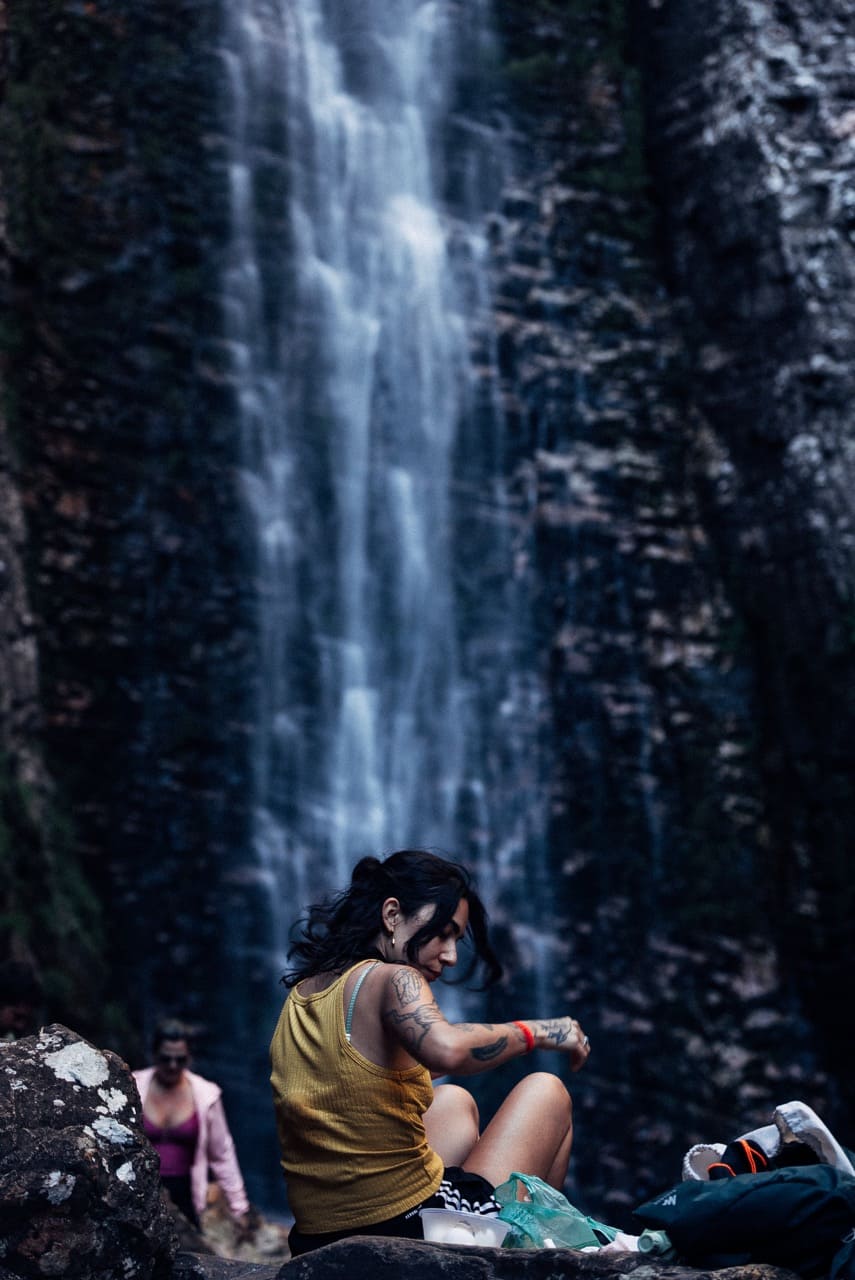 Cachoeira ao fundo — pausa nas pedras