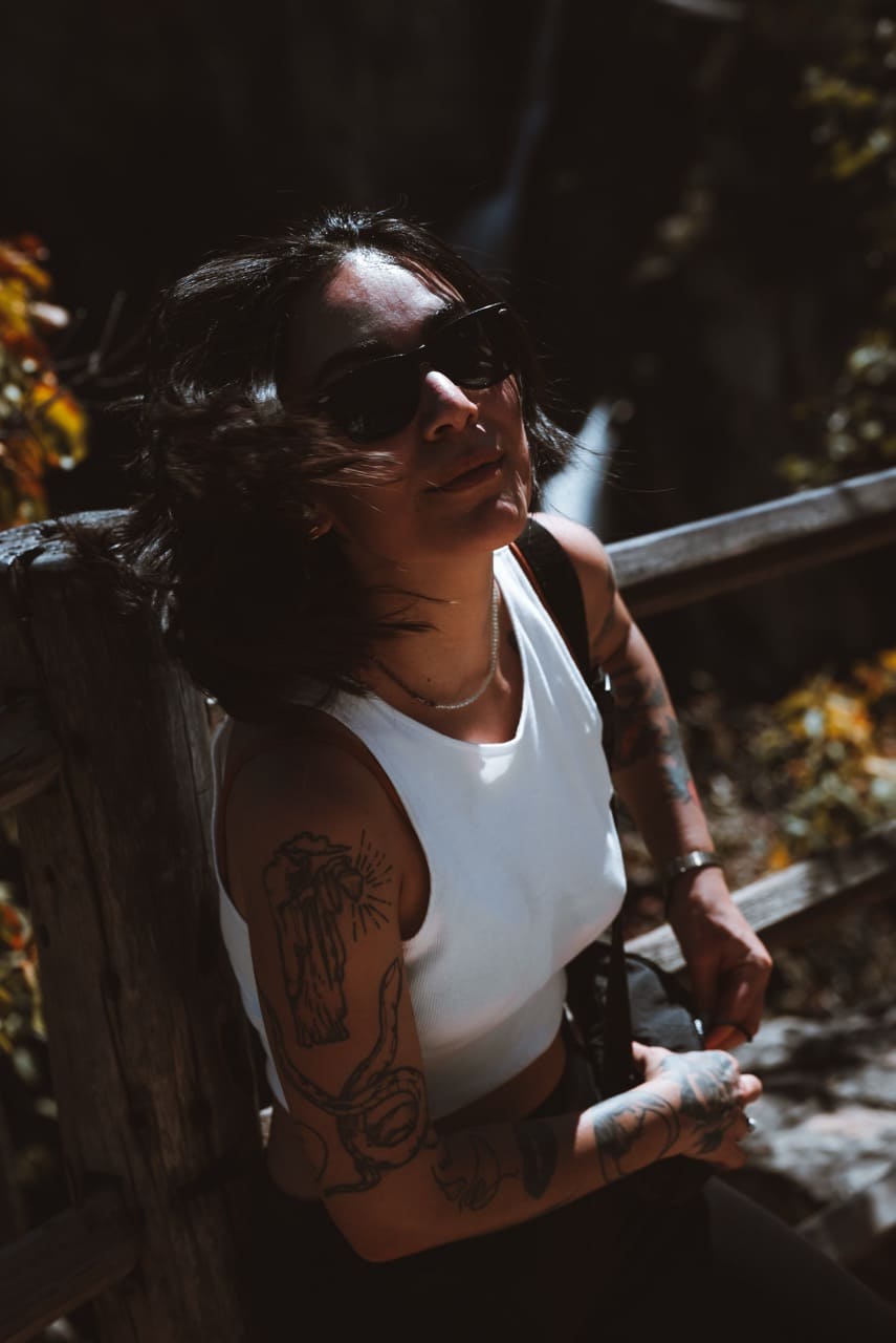 Retrato — luz quente entre folhas