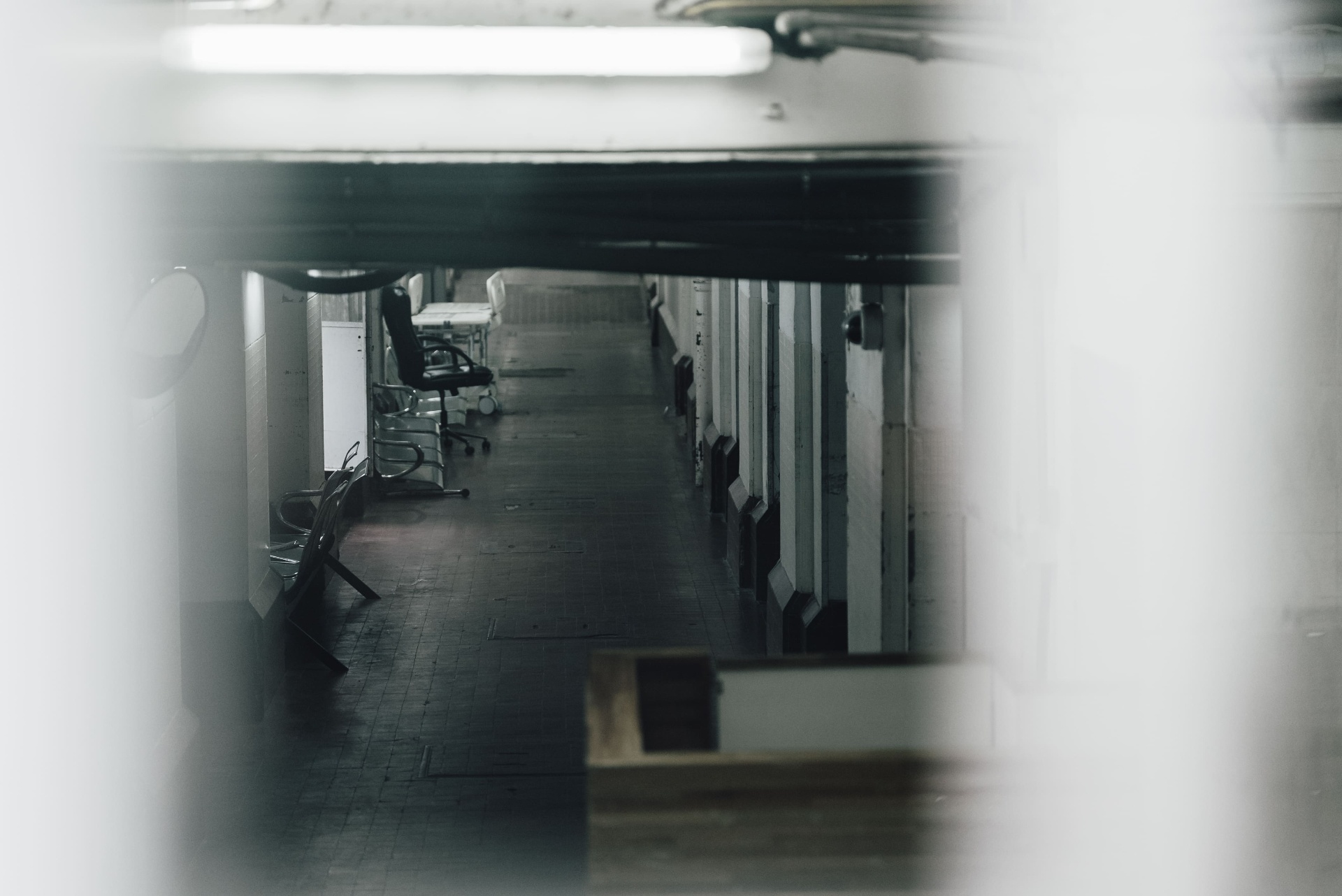 Corredor interno visto por frestas, em composição cinematográfica
