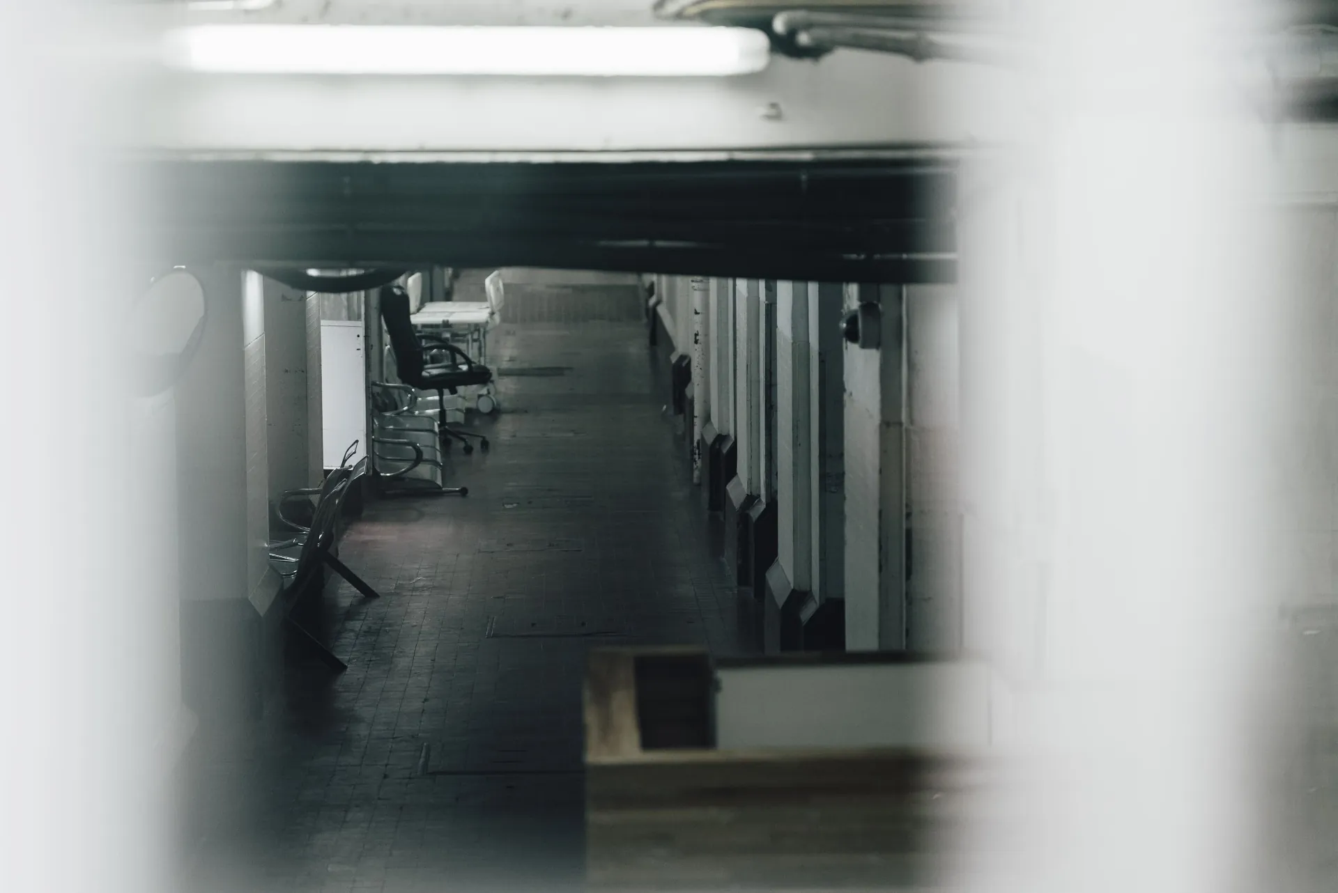 Corredor interno visto por frestas, em composição cinematográfica