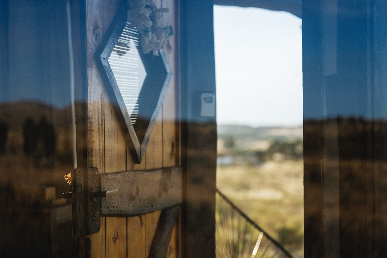 Porta de madeira e vidro com vista para o campo