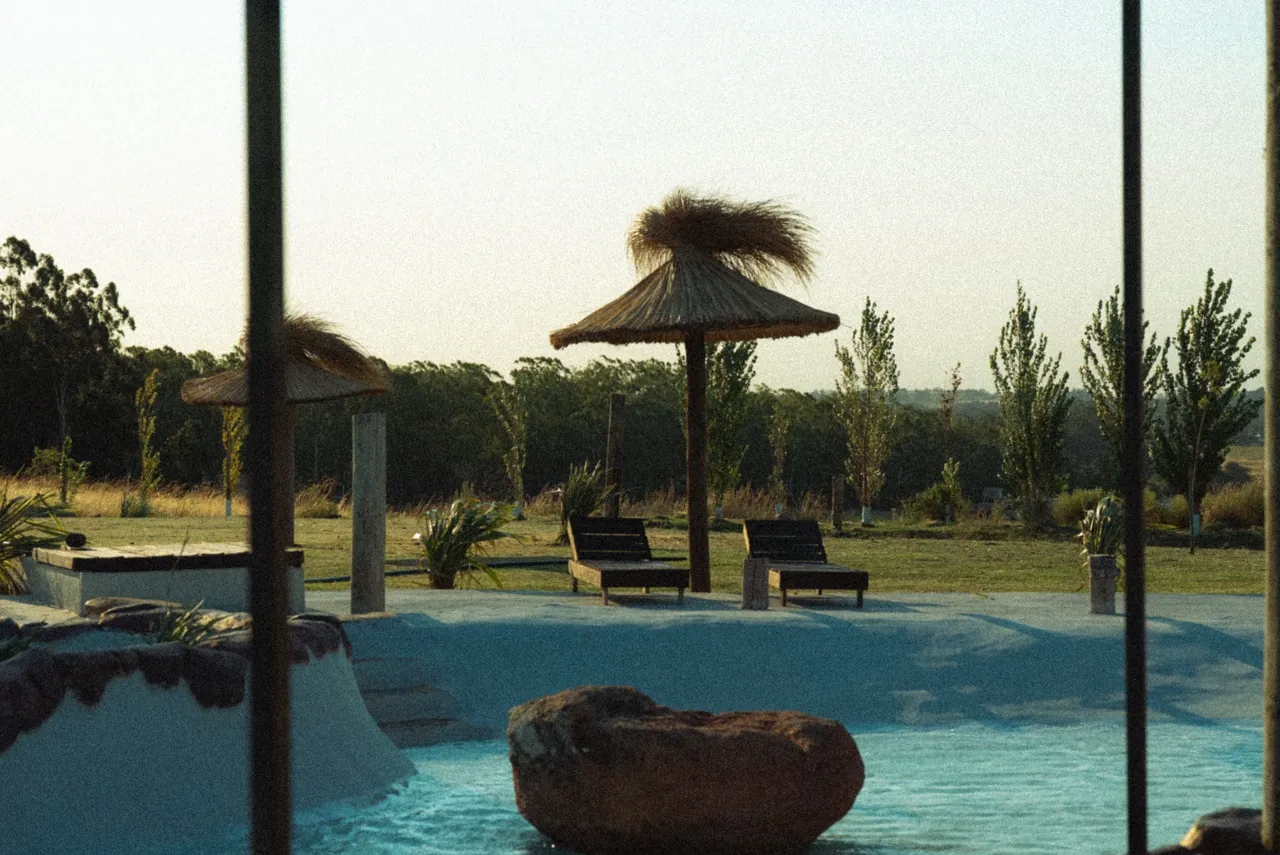 Piscina e ombrelones de palha