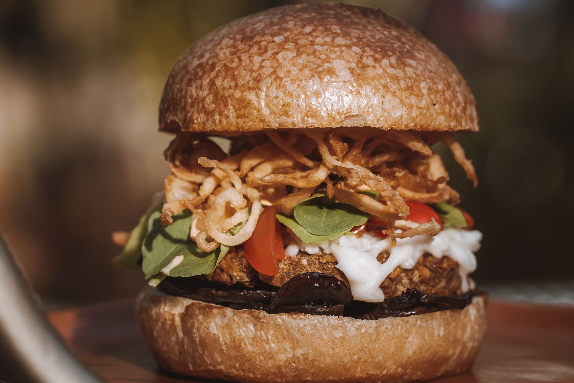 Hambúrguer vegano com cebola crispy e tomate