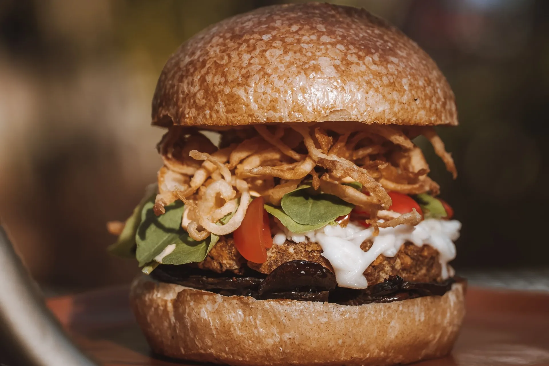 Hambúrguer vegano com cebola crispy e tomate