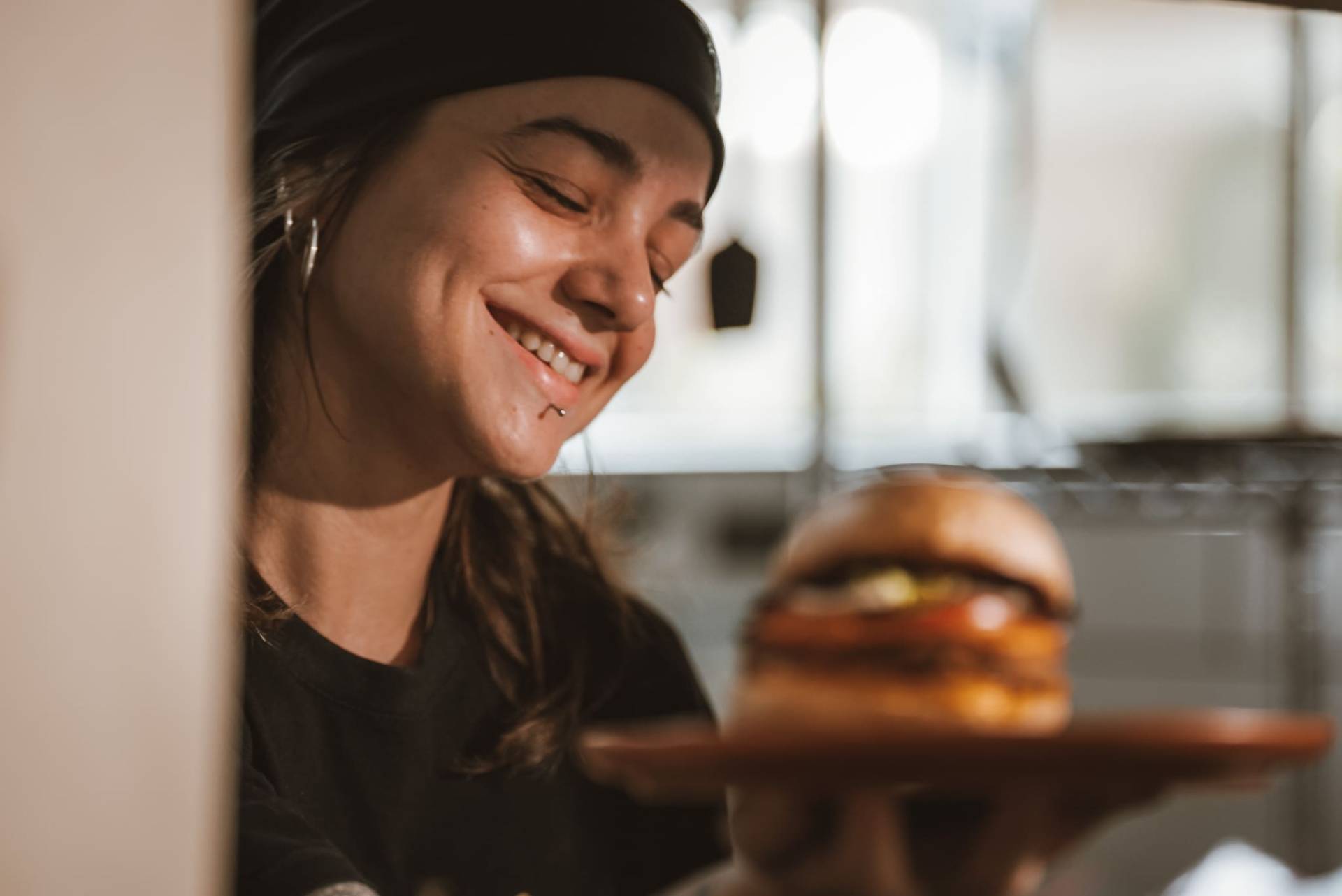 Cozinheira sorrindo com o hambúrguer